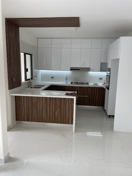 Cocina en U con gabinetes blancos arriba y nogal imperial abajo, en Santa Fe, Culiacán
