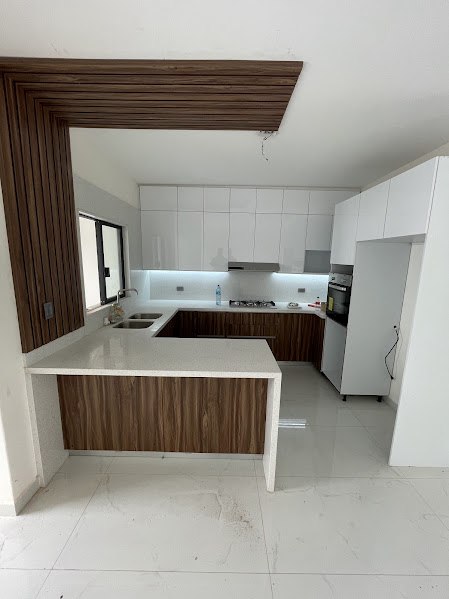 Península de la cocina con cubierta de cuarzo y frente en nogal imperial