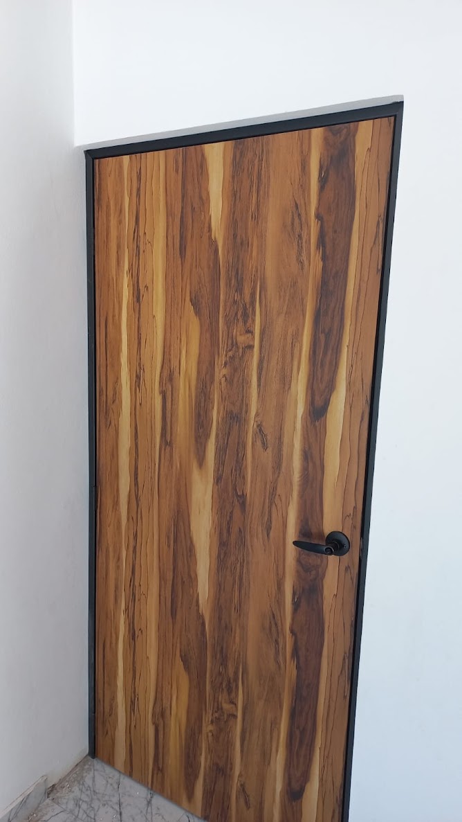 Puerta de melamina de 3 mm color Parota con manija Dexter negra y marco de acero de 6 cm